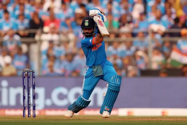 Virat Kohli playing a perfect cover drive, showcasing his elegant batting technique on the cricket field.